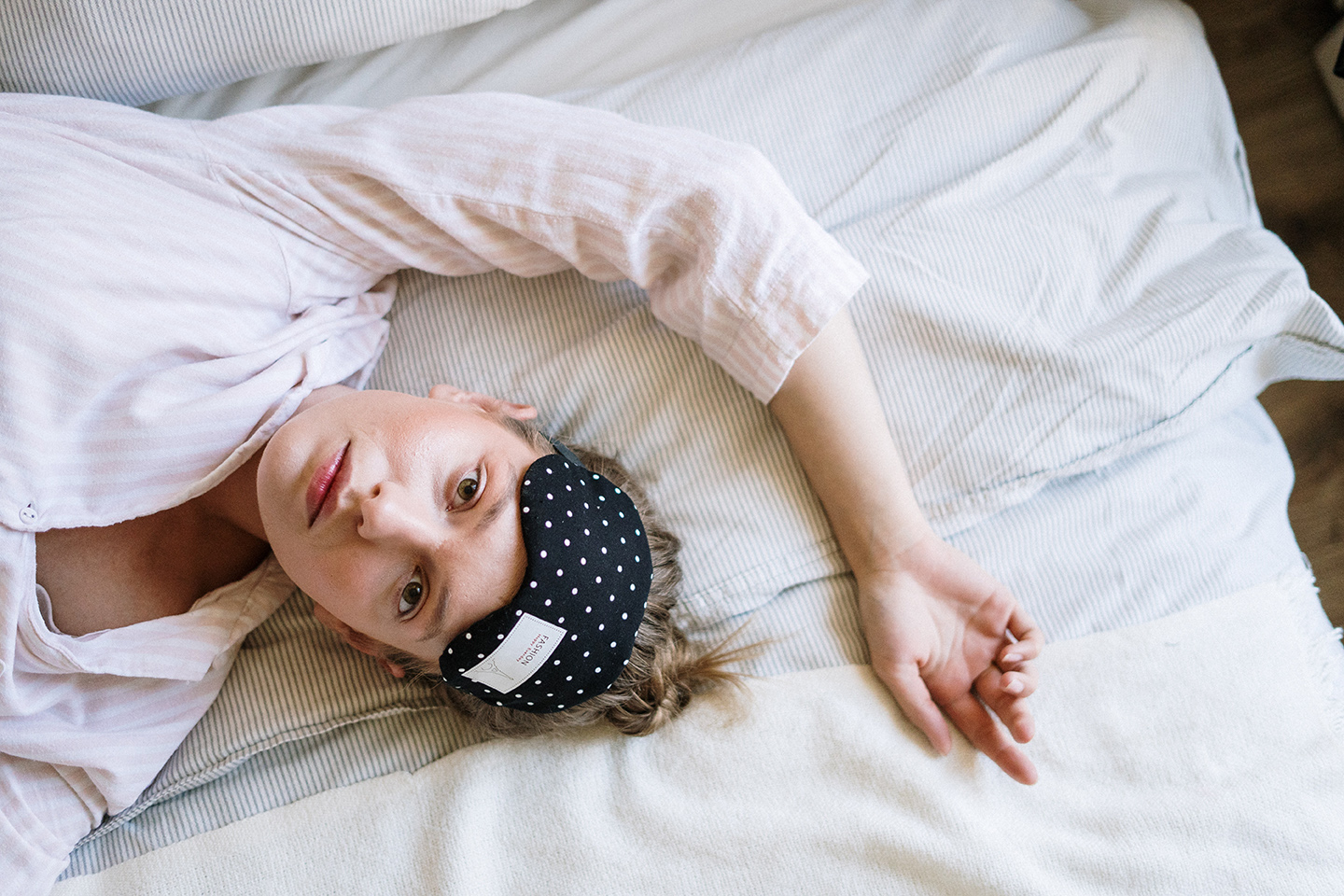 Close up of woman in bed, awake with sleep mask on forehead
